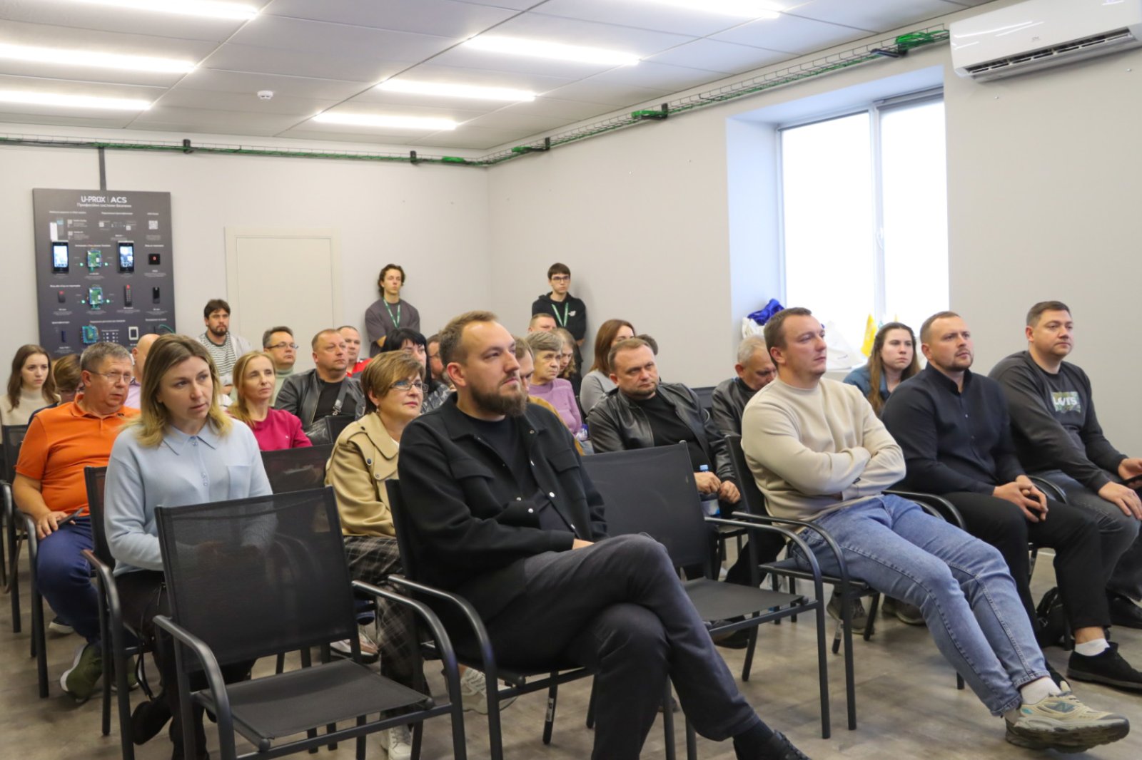Багато людей сидять у приміщенні.